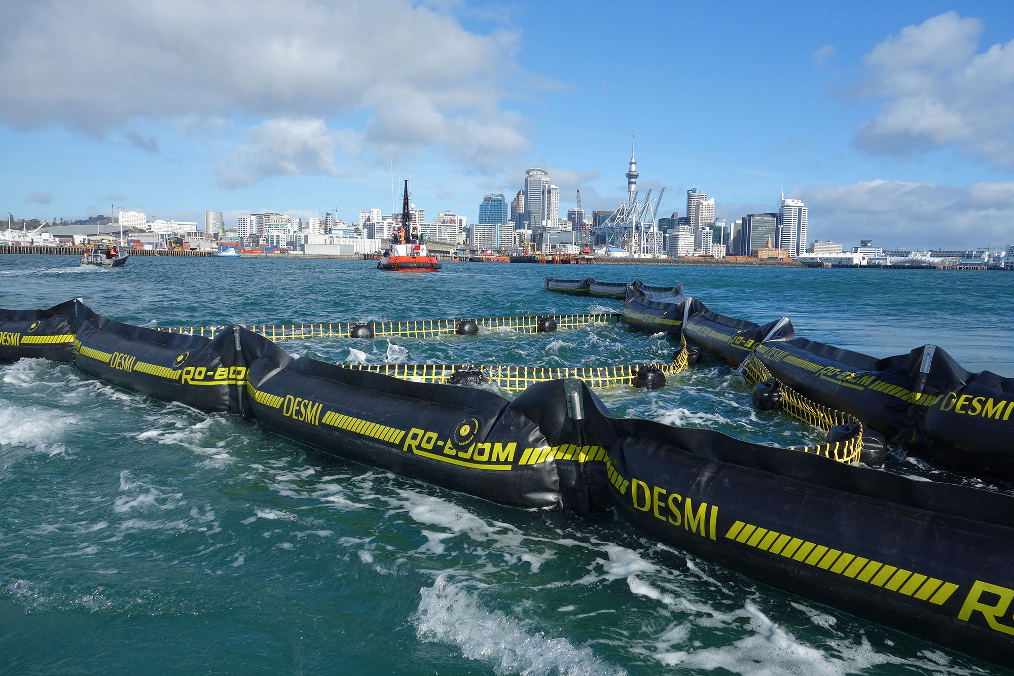 DESMI RO-BOOM in water with city skyline in the background.