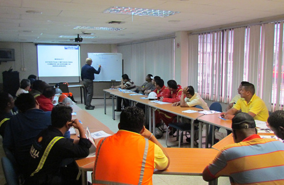 Classroom training session on oil spill response methods with diverse participants.