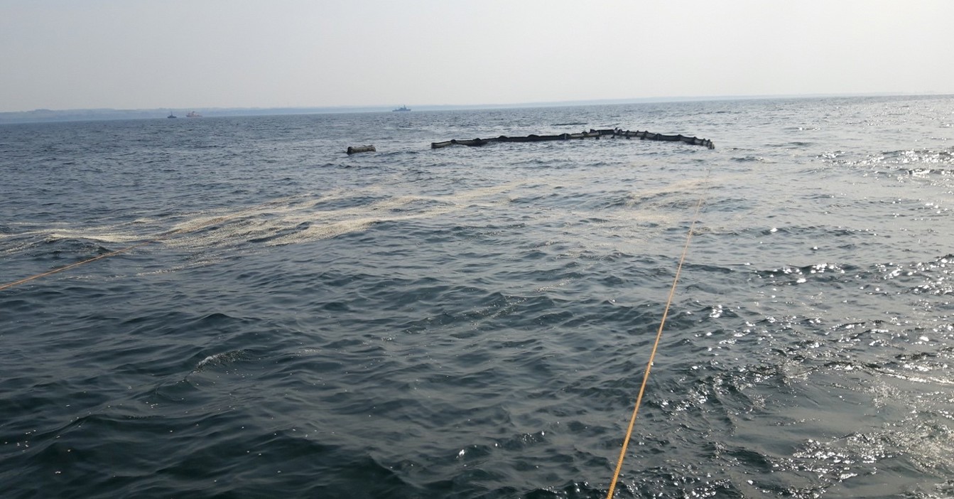 Oil spill containment boom floating on the ocean surface.