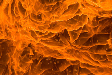 Vivid, swirling flames creating a dynamic, fiery pattern in orange and yellow hues.