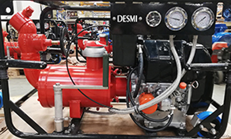 DESMI pump system with gauges and red piping for fluid handling.
