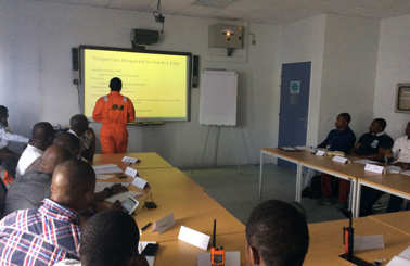 Classroom session with a presentation on predicting fate, led by instructor in orange.