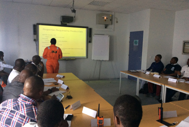Classroom session with a presentation on predicting fate, led by instructor in orange.