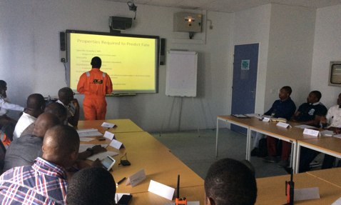 Classroom session with a presentation on predicting fate, led by instructor in orange.