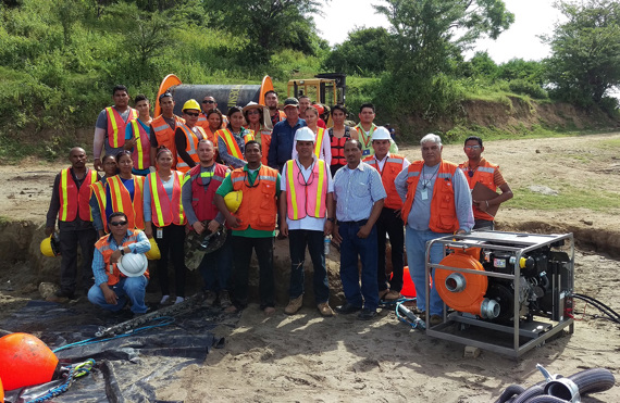 Group of workers in safety vests at a construction site with DESMI equipment.