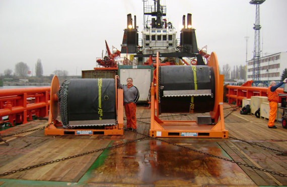 Two large industrial reels on deck with workers, labeled "DESMI."