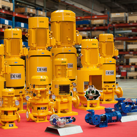 Yellow DESMI pumps for fluid handling displayed in a warehouse setting.