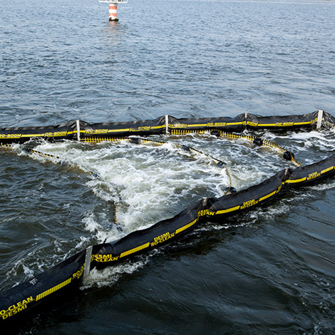 DESMI oil containment boom deployed on water for spill control.